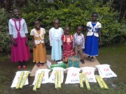 Children sponsored by Mama Linda pausing for a photo in their new clothes and other items they bought